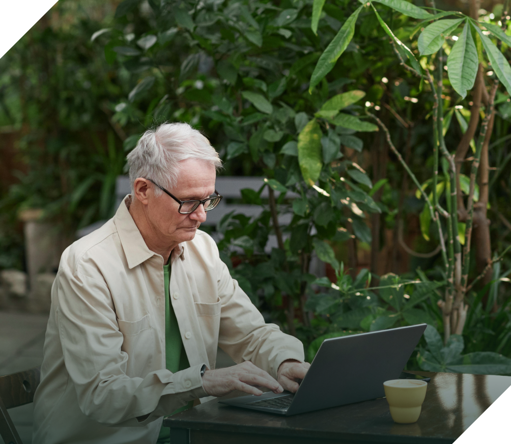 Man sitting in front of a laptop outside