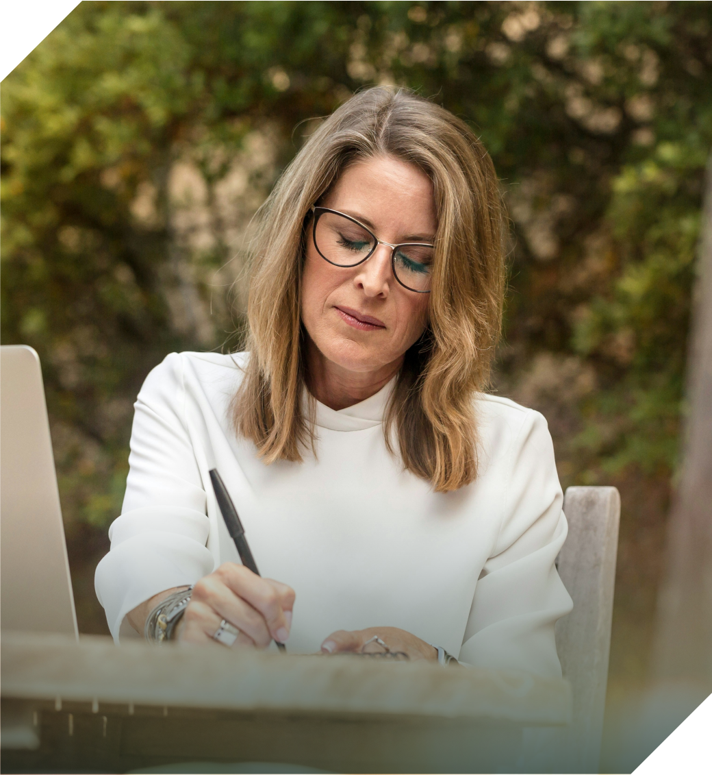 Lady with gray hair writing outside